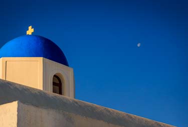 Sunrise picture of a Santorini blue domed church roof