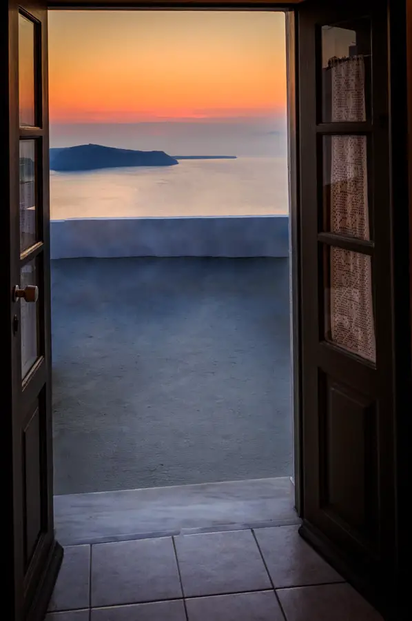 Sunset view of the caldera through the doors of a room at Kasima