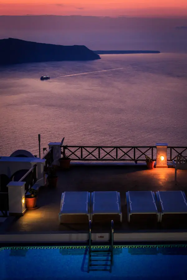 Sunset view of a swimming pool and the amazing sea of Santorini