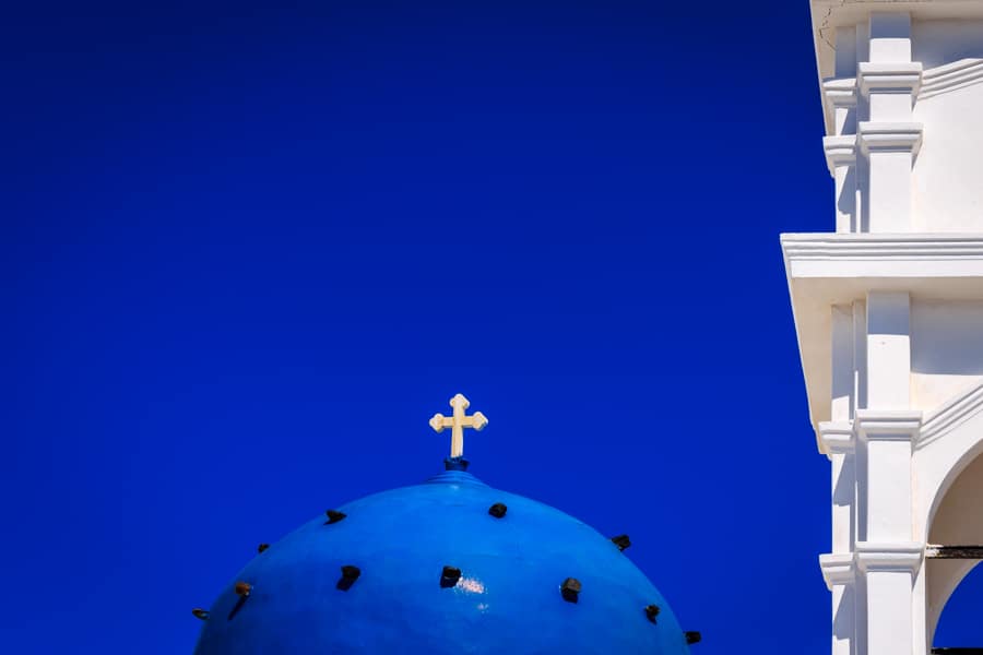 Blue dome and gold cross with a blue Santorini sky